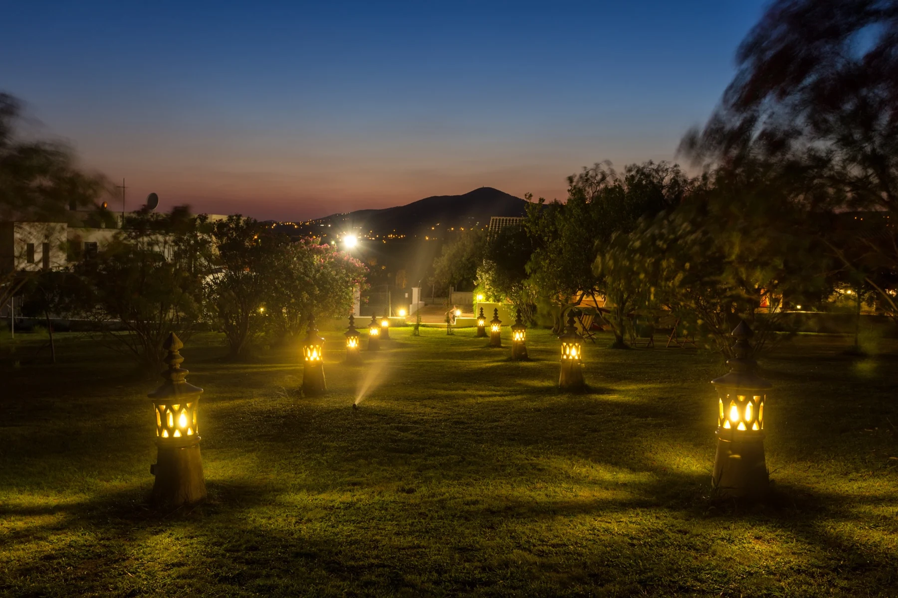 Allée illuminée dans le jardin d’As Casas do Algarve à la tombée de la nuit